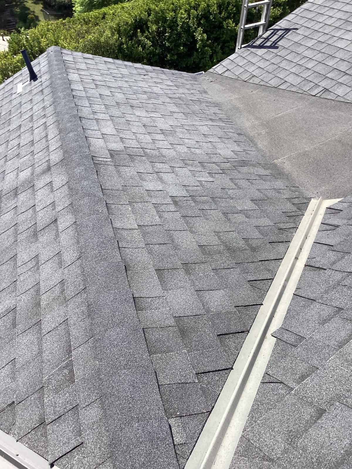 Gray asphalt shingle roof with metal valley flashing and flat roof section in Beverly Hills | Roof Replacement Inc Gray asphalt shingle roof with metal valley flashing and flat roof section — Beverly Hills — Roof Replacement Inc