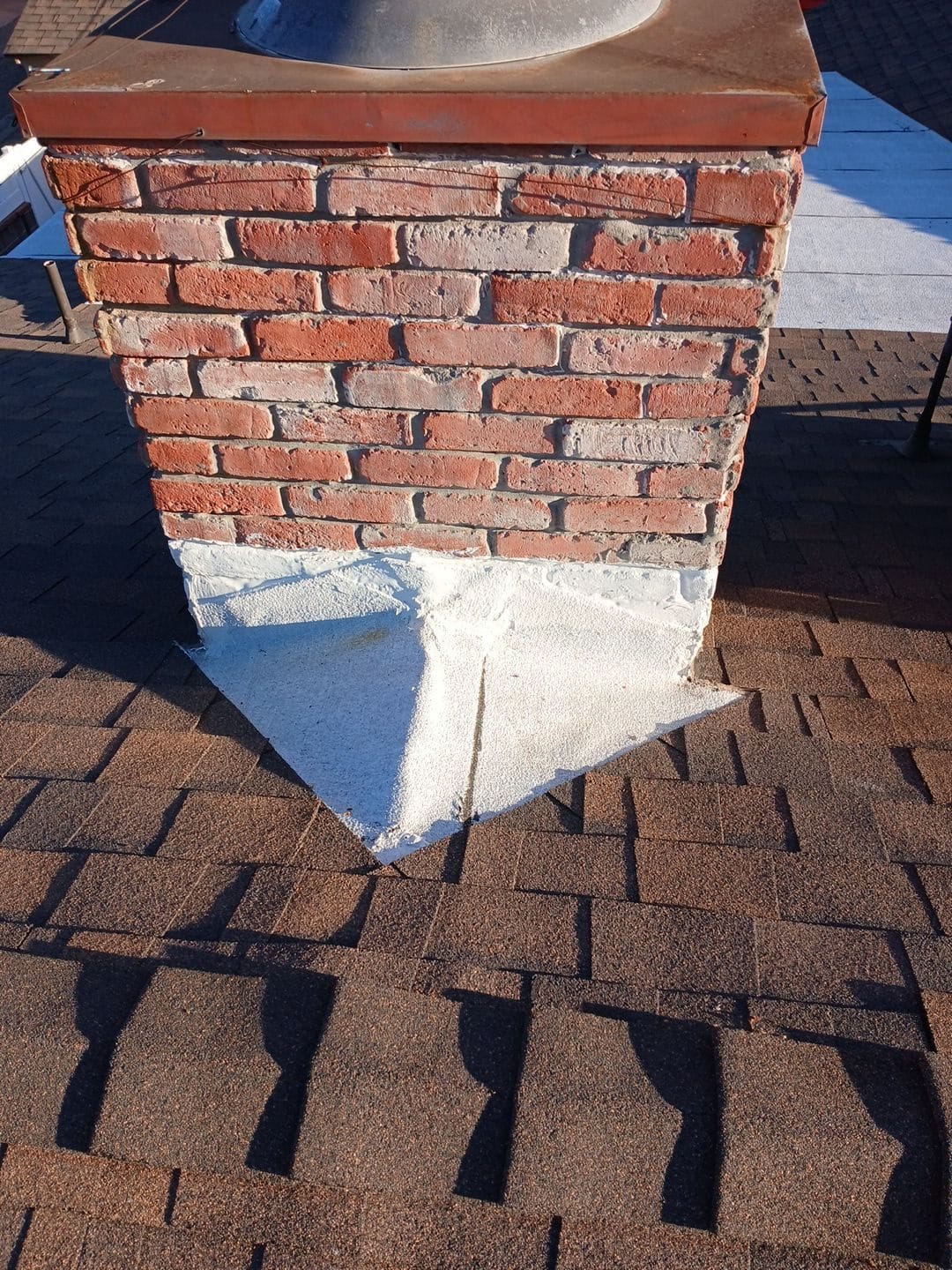 Brick chimney with white mortar base flashing on asphalt shingle roof — Van Nuys — Roof Replacement Inc