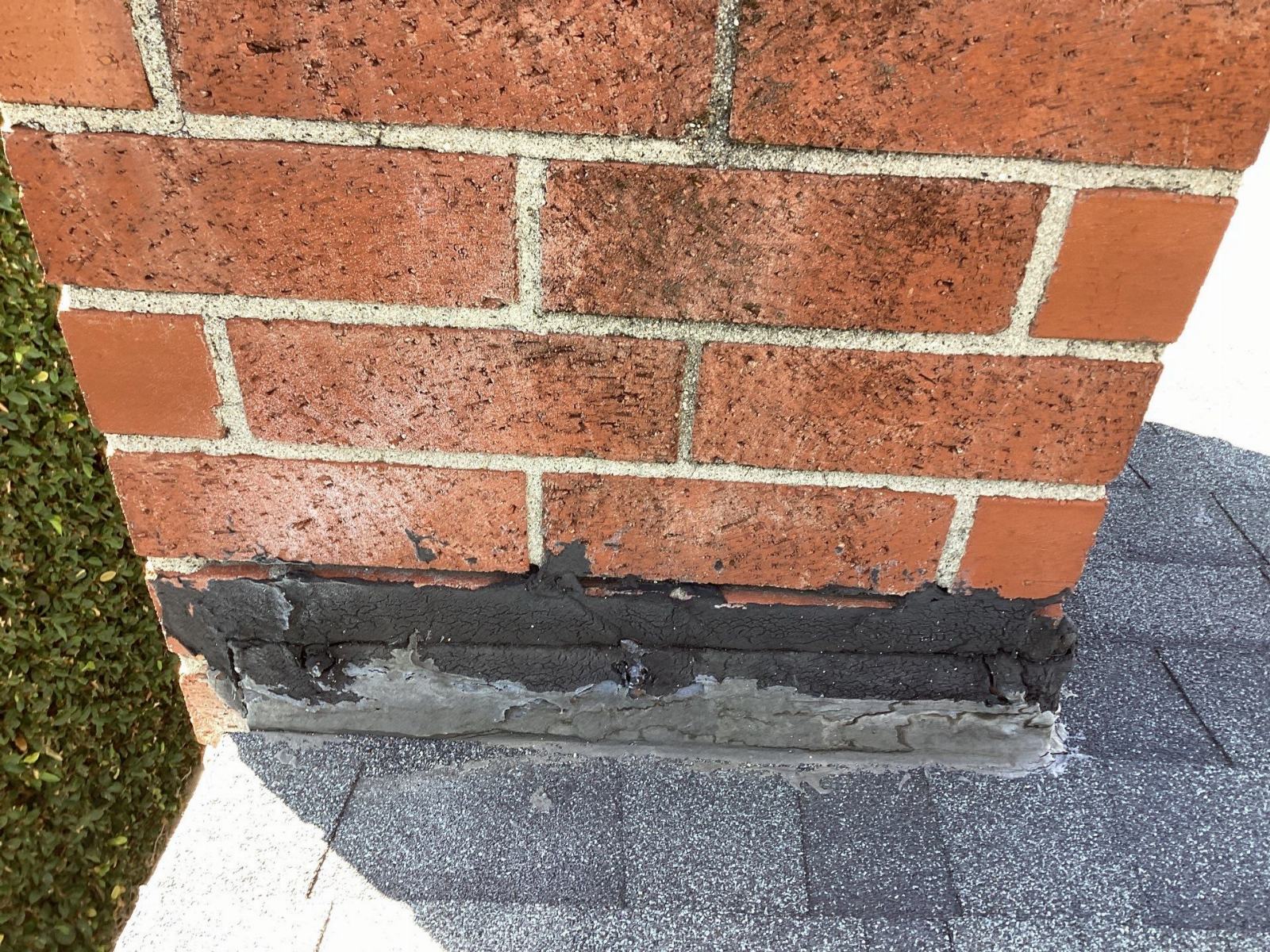 Deteriorated tar flashing at chimney-roof junction, asphalt shingles in Calabasas | Roof Replacement Inc Deteriorated tar flashing at chimney-roof junction, asphalt shingles — Calabasas — Roof Replacement Inc