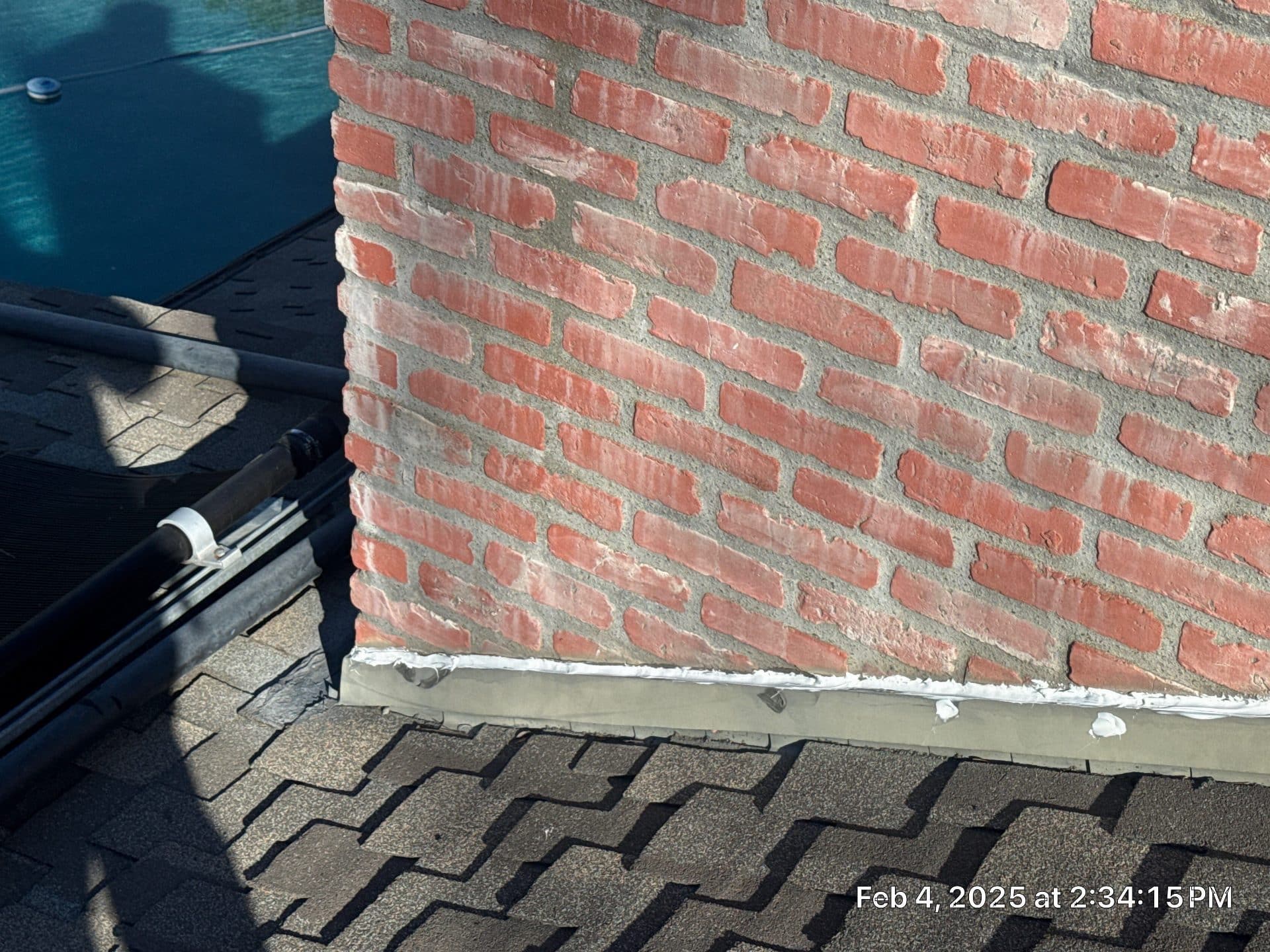 Brick chimney base flashing on asphalt shingle roof in Sherman Oaks | Roof Replacement Inc Brick chimney base flashing on asphalt shingle roof — Sherman Oaks — Roof Replacement Inc