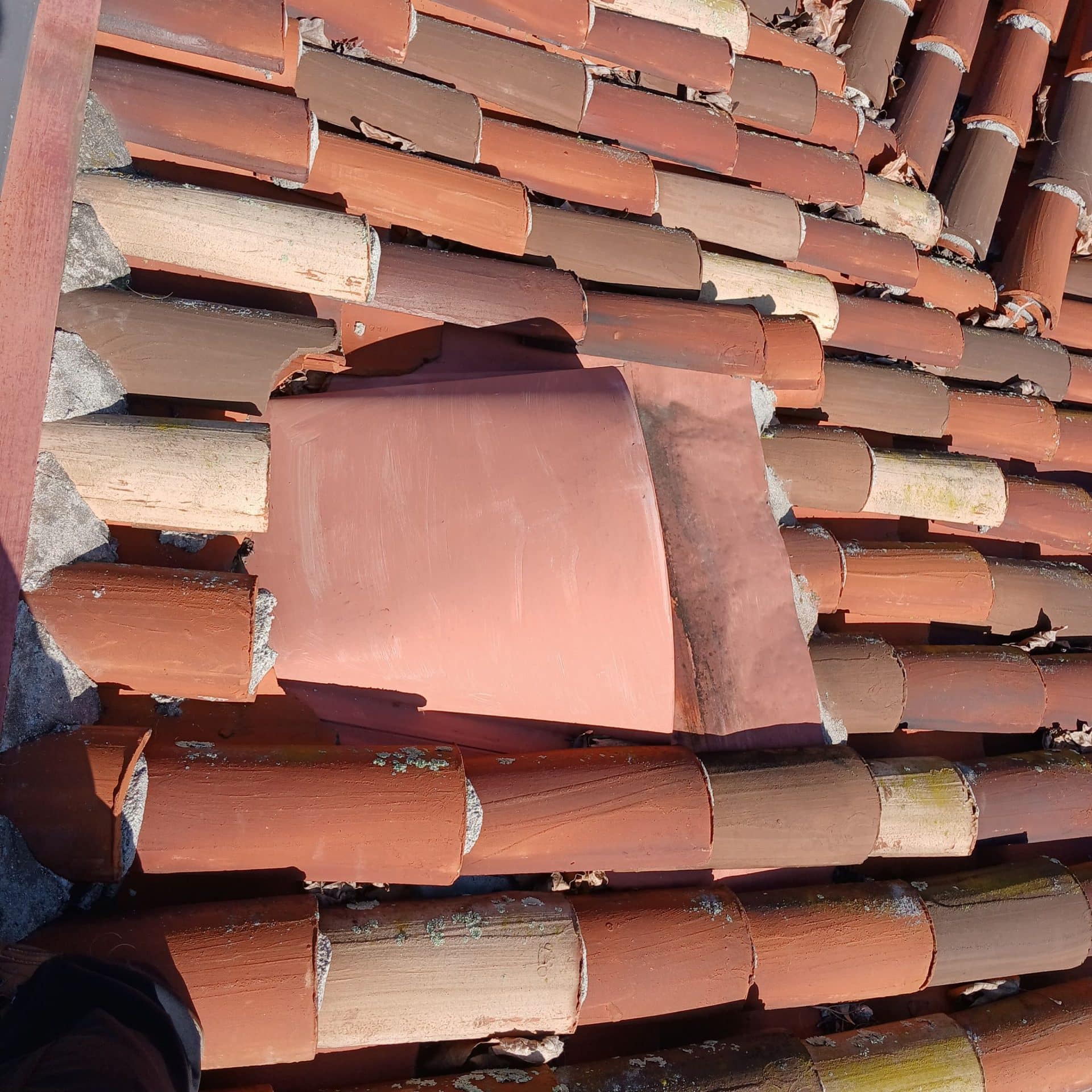 Stacked clay barrel roof tiles, one flat tile displaced in Malibu | Roof Replacement Inc Stacked clay barrel roof tiles, one flat tile displaced — Malibu — Roof Replacement Inc