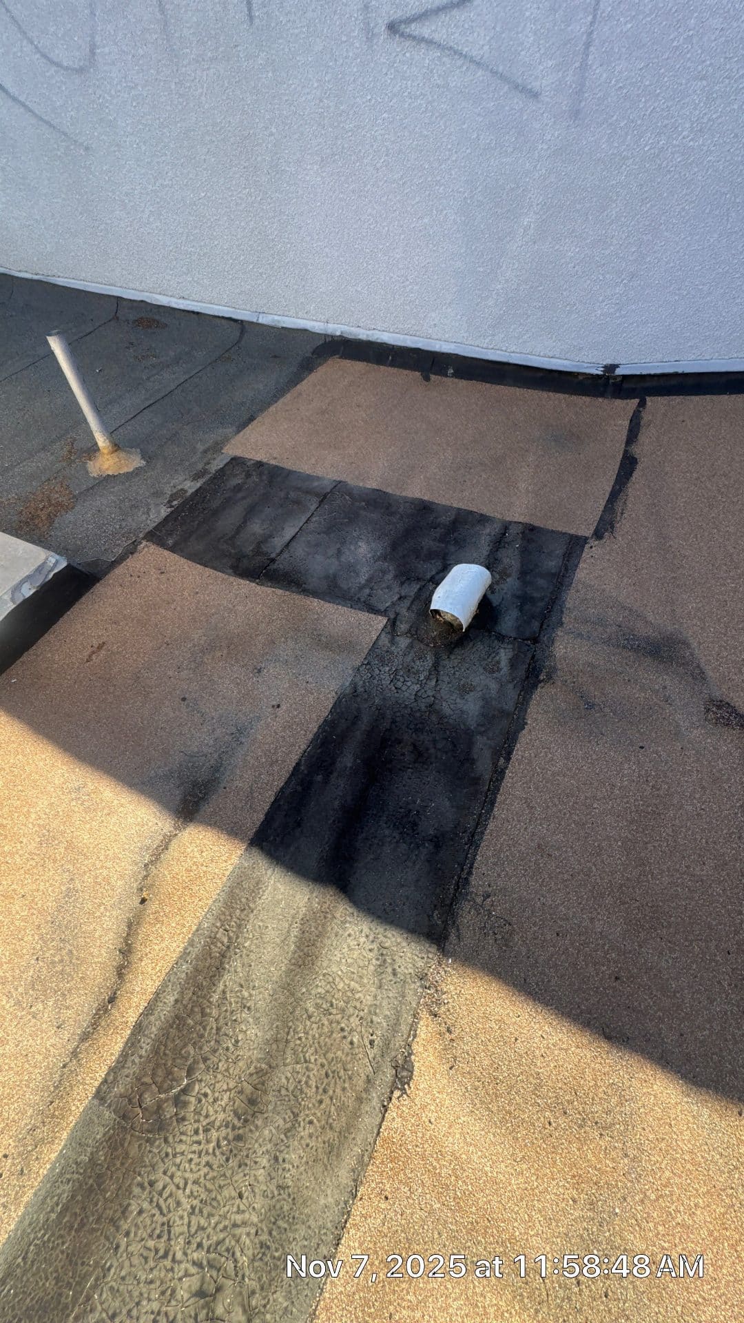 Flat roof with torch-down bitumen patches around pipe penetration in Panorama City | Roof Replacement Inc Flat roof with torch-down bitumen patches around pipe penetration — Panorama City — Roof Replacement Inc