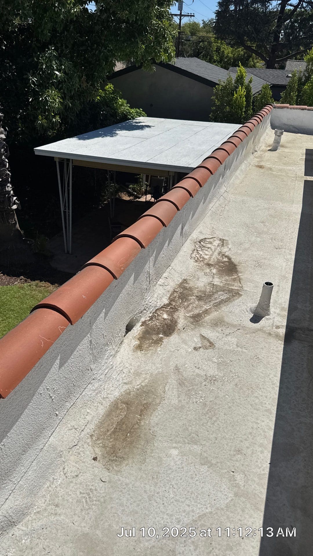 Flat roof with parapet wall, clay tile coping, and pipe penetrations in North Hollywood | Roof Replacement Inc Flat roof with parapet wall, clay tile coping, and pipe penetrations — North Hollywood — Roof Replacement Inc