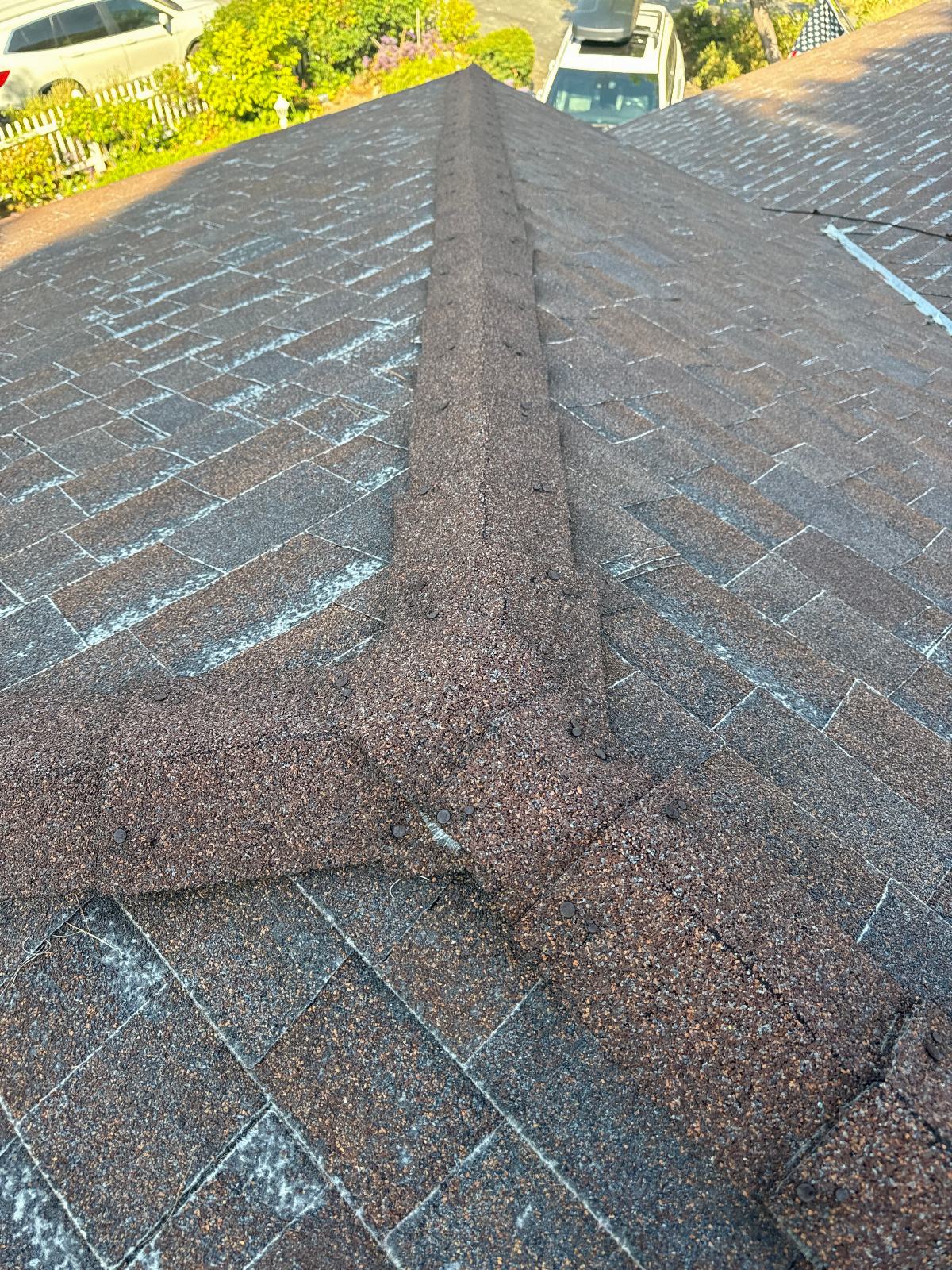 Asphalt shingle hip roof ridge junction, brown granules, exposed nails in La Crescenta-Montrose | Roof Replacement Inc Asphalt shingle hip roof ridge junction, brown granules, exposed nails — La Crescenta-Montrose — Roof Replacement Inc