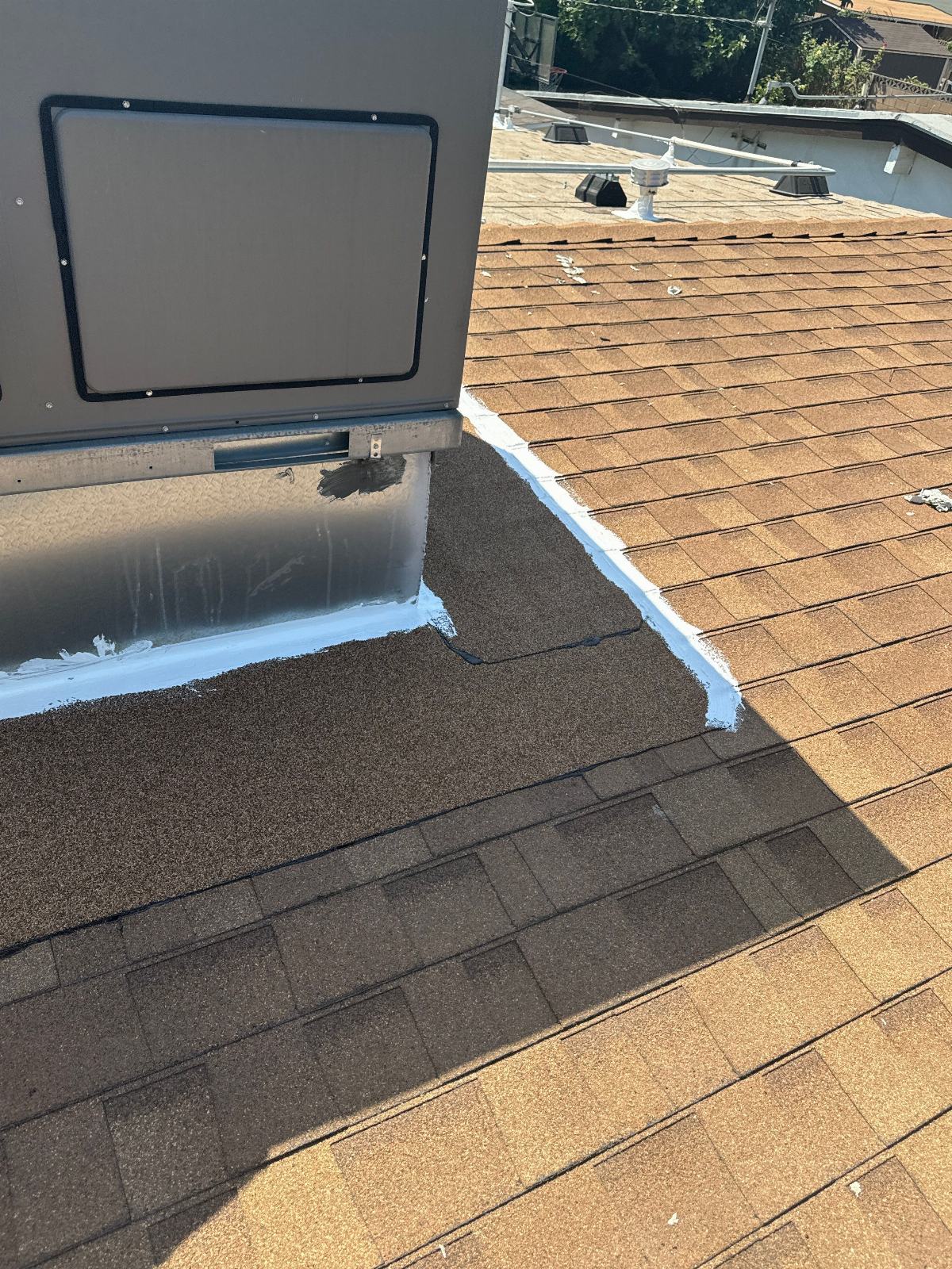 Curb flashing sealed with white sealant on an asphalt shingle roof | Roof Replacement Inc Curb flashing sealed with white sealant on an asphalt shingle roof — Roof Replacement Inc