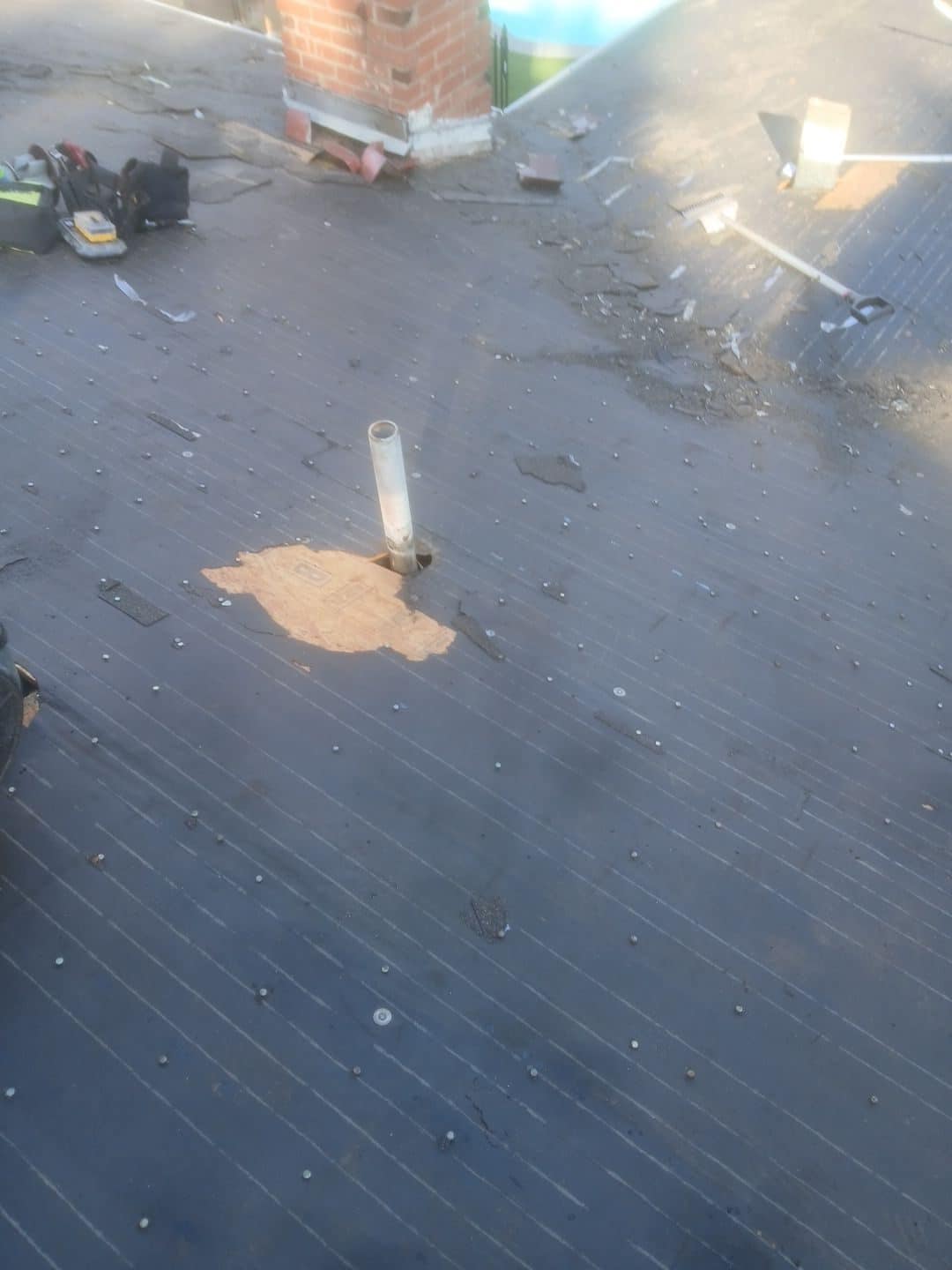 Roof deck with underlayment, pipe penetration, chimney, torn-off shingles debris in Van Nuys | Roof Replacement Inc Roof deck with underlayment, pipe penetration, chimney, torn-off shingles debris — Van Nuys — Roof Replacement Inc