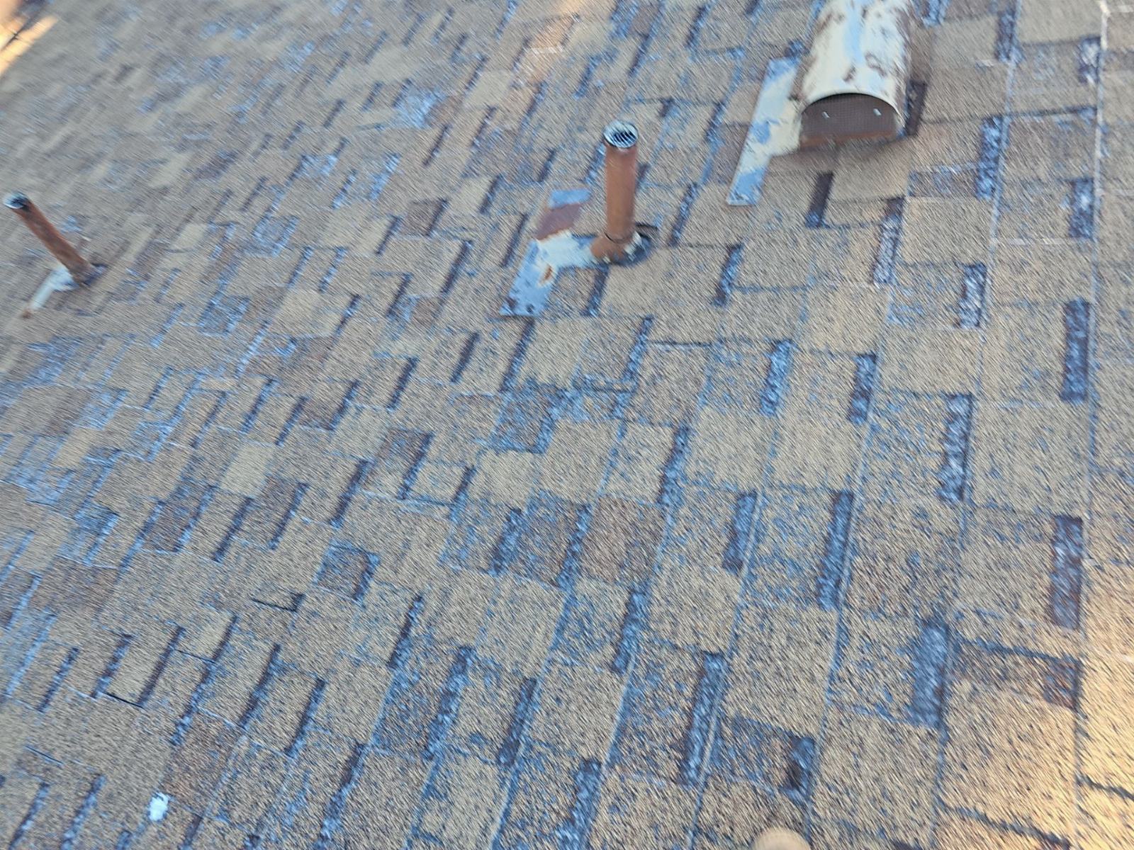 Stripped roof deck with felt underlayment, pipe penetrations, and old vent pipe in Santa Clarita | Roof Replacement Inc Stripped roof deck with felt underlayment, pipe penetrations, and old vent pipe — Santa Clarita — Roof Replacement Inc