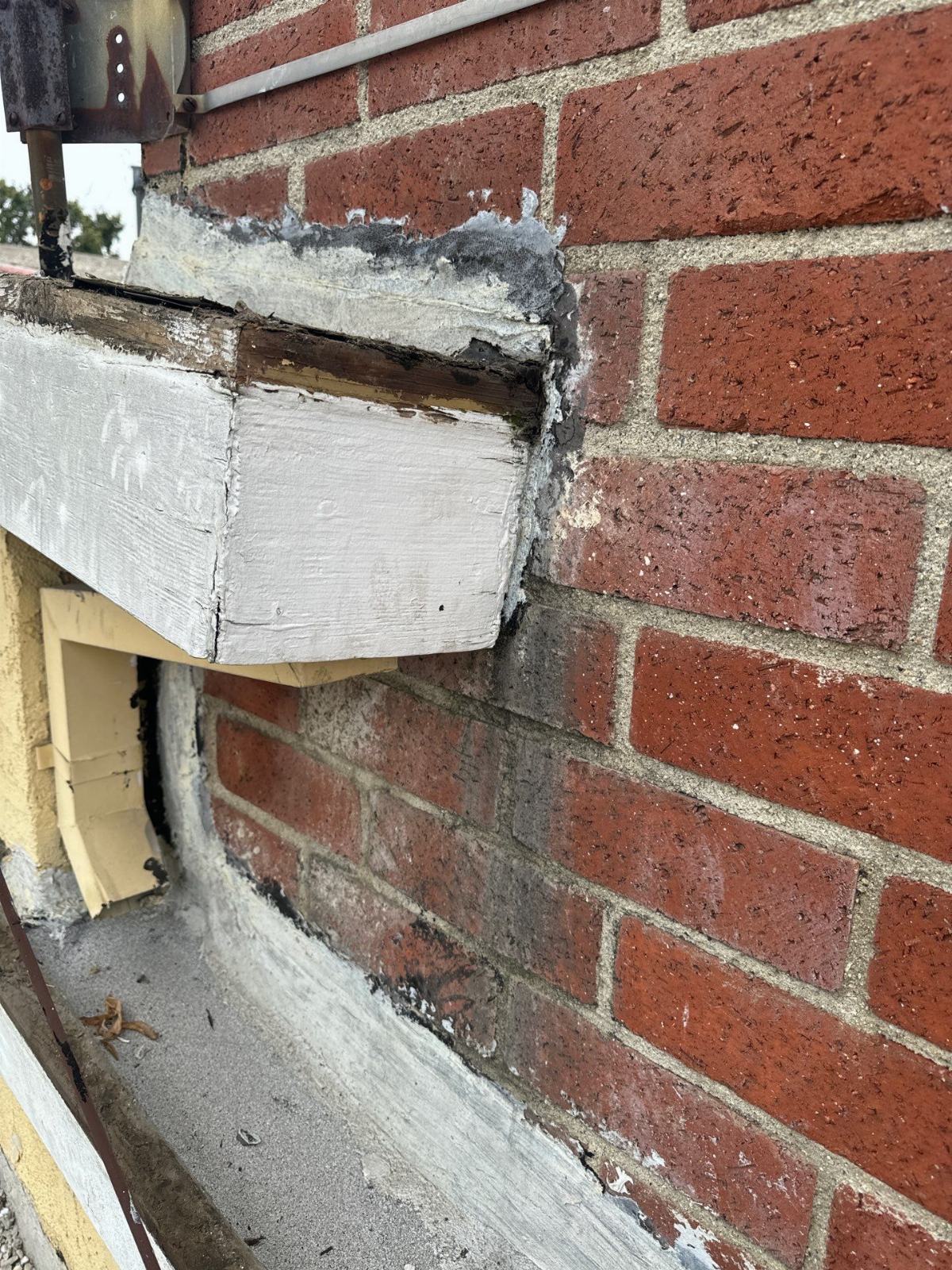 Deteriorated wooden fascia board meeting brick wall, failed sealant visible in Panorama City | Roof Replacement Inc Deteriorated wooden fascia board meeting brick wall, failed sealant visible — Panorama City — Roof Replacement Inc