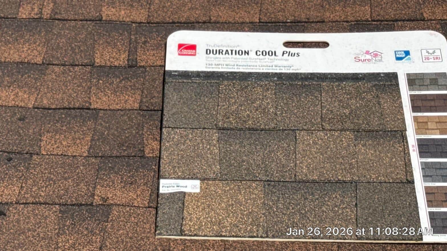 Owens Corning TruDefinition Duration Cool Plus Prairie Wood shingle sample held against existing roof surface