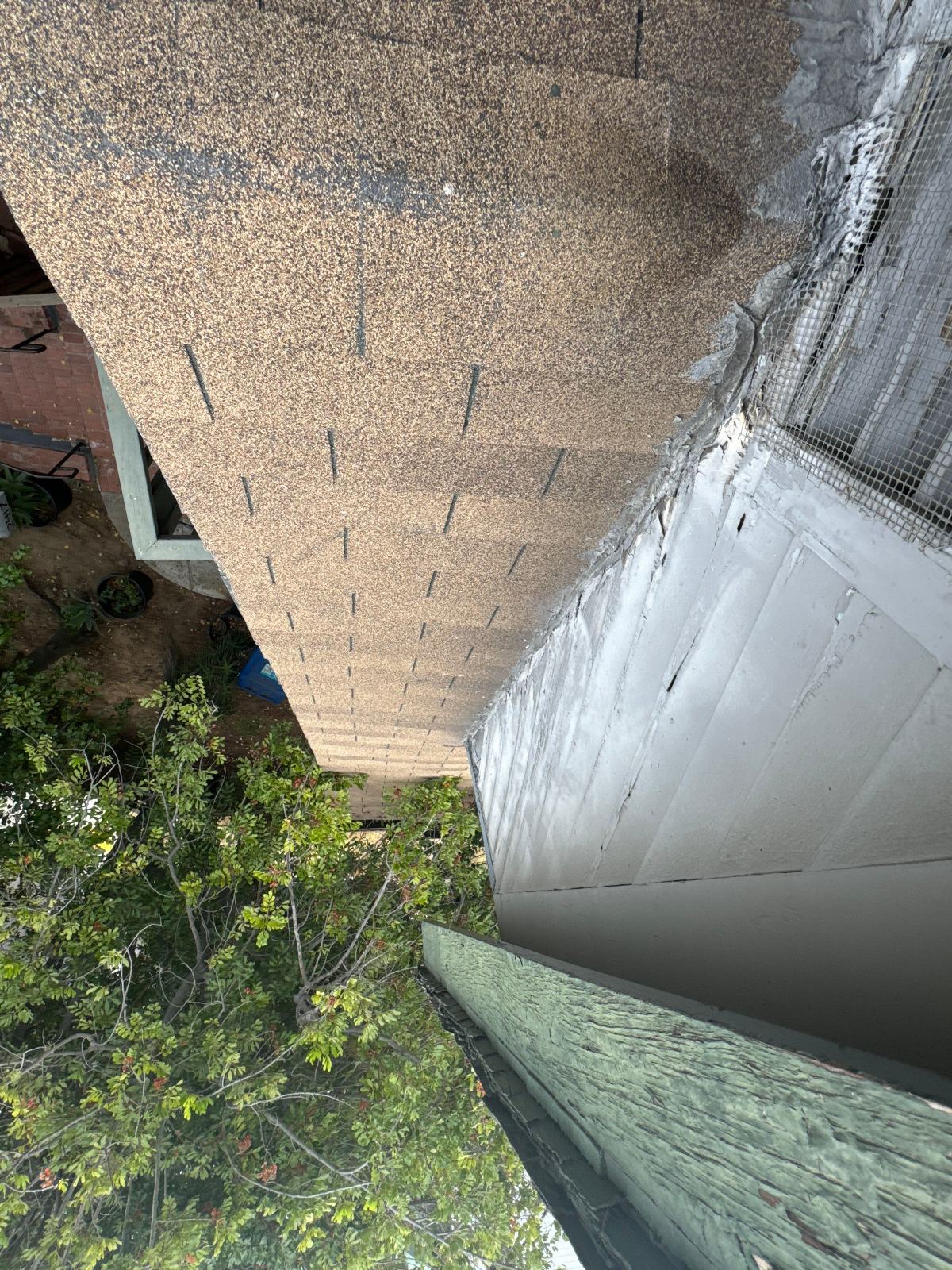 Asphalt shingle roof edge meeting stucco wall with mesh reinforcement in Echo Park | Roof Replacement Inc Asphalt shingle roof edge meeting stucco wall with mesh reinforcement — Echo Park — Roof Replacement Inc