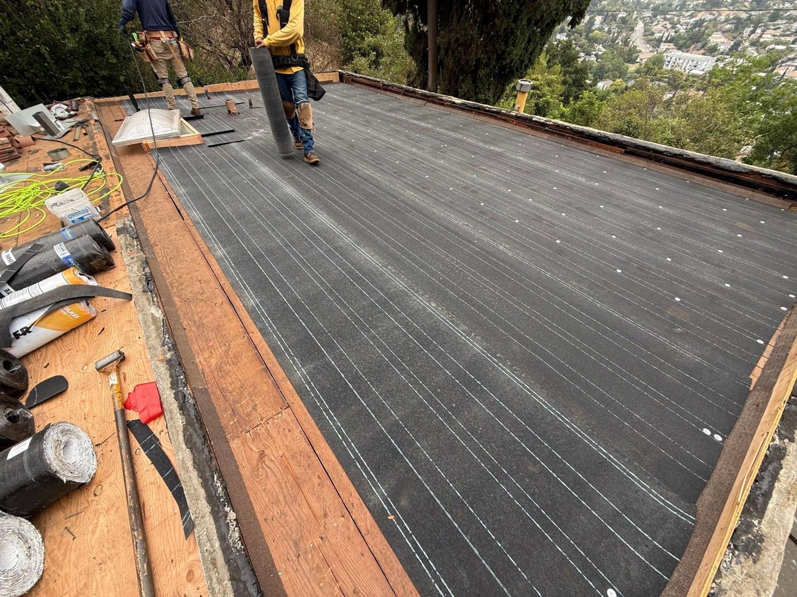 White elastomeric roof coating applied to a flat California commercial roof under summer sun