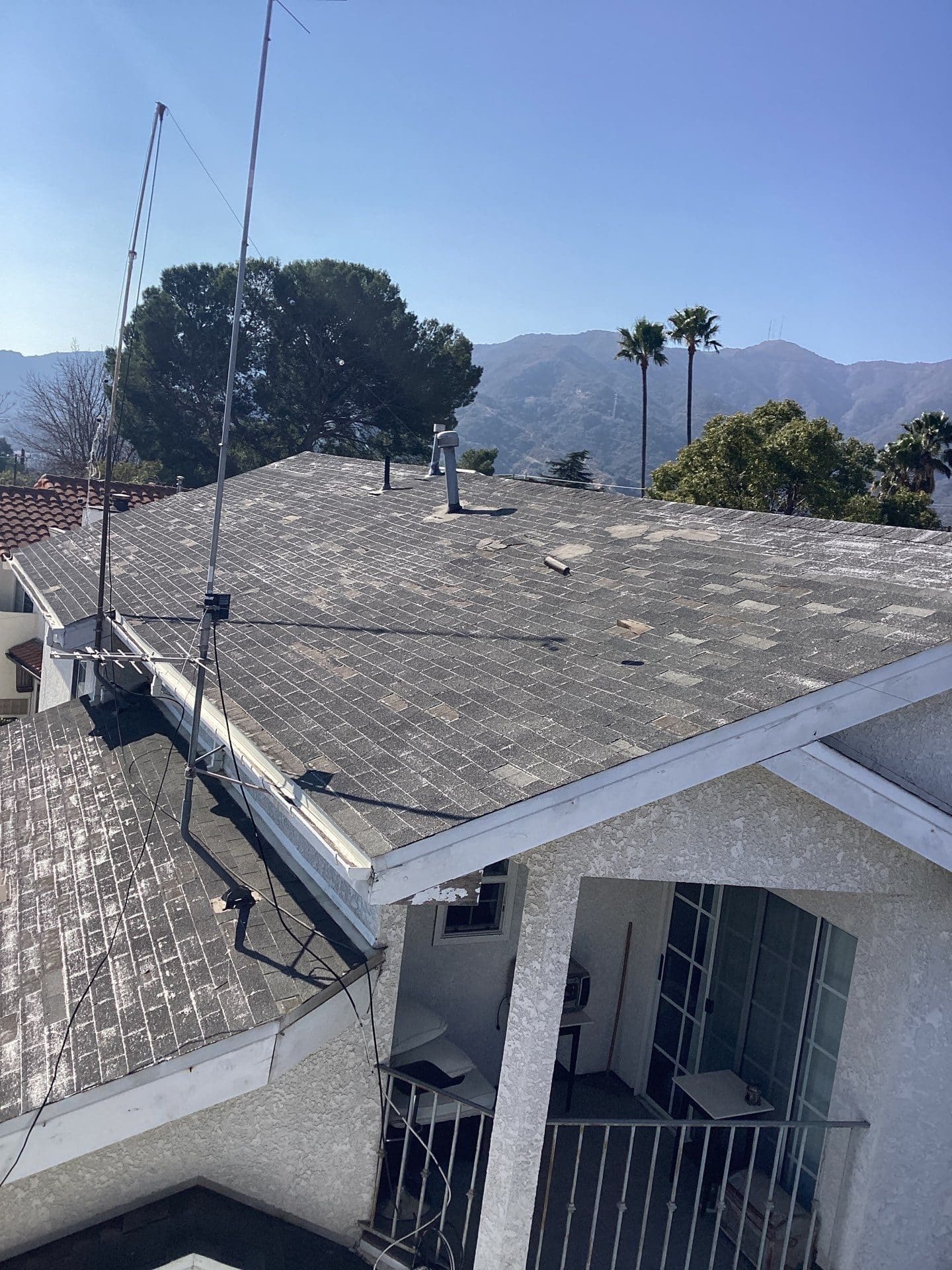 Aged asphalt shingle roof with TV antenna and vent pipe in La Crescenta-Montrose | Roof Replacement Inc Aged asphalt shingle roof with TV antenna and vent pipe — La Crescenta-Montrose — Roof Replacement Inc