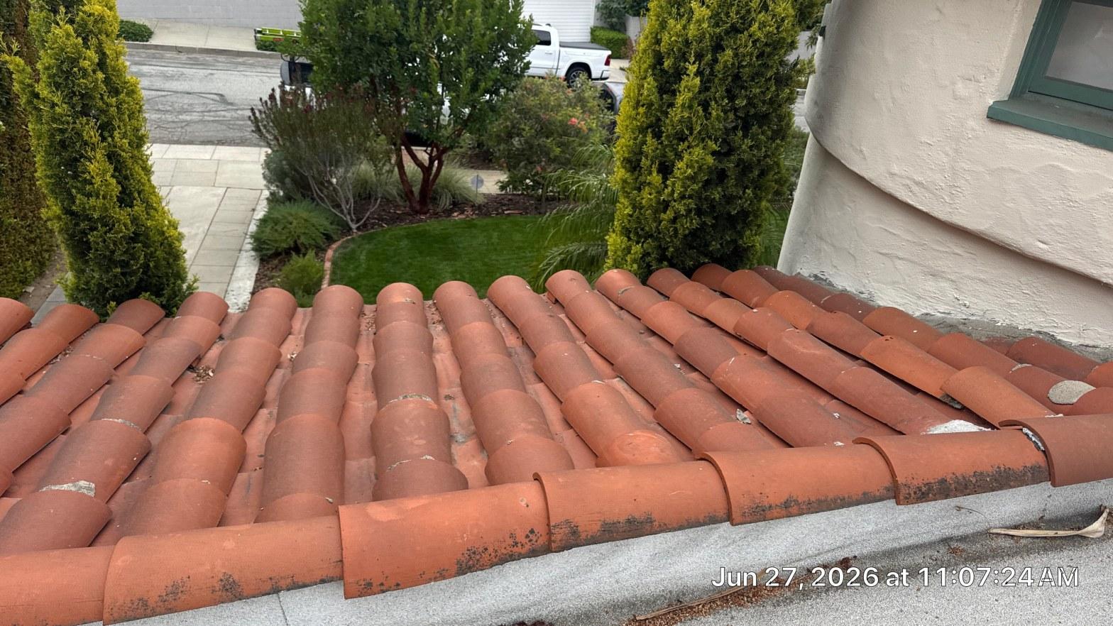 Clay barrel tile roof on Spanish-style stucco home with landscaped front yard, Los Angeles County