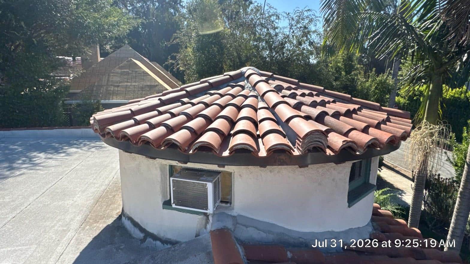Completed circular tower roof with radial clay barrel tile pattern on white stucco structure