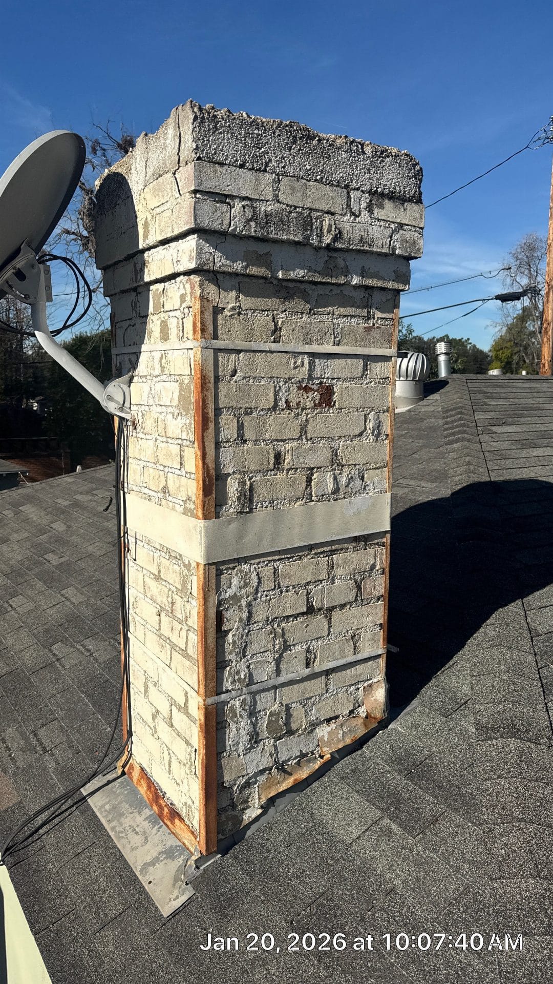 Deteriorated brick chimney with rusted flashing on asphalt shingle roof — Burbank — Roof Replacement Inc