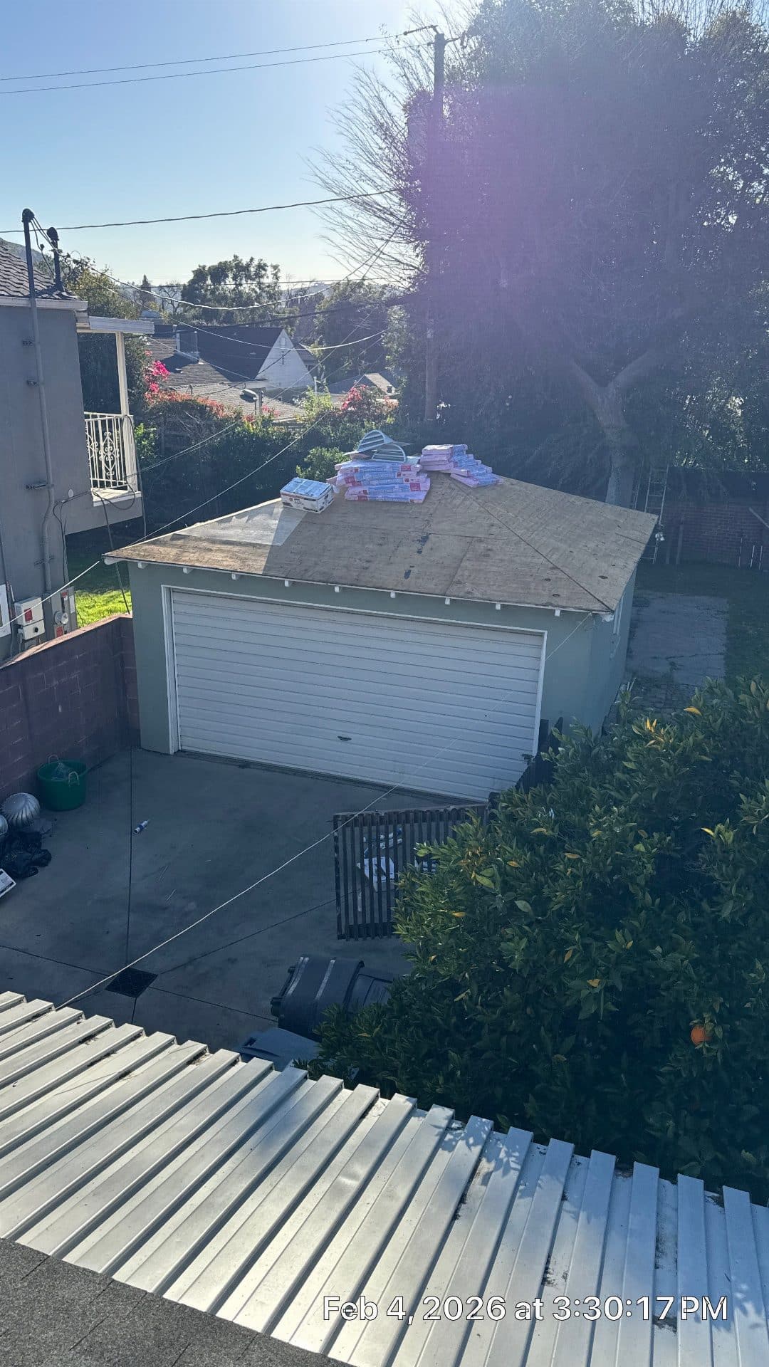 Detached garage roof stripped to OSB decking, new shingle bundles staged on top — Burbank — Roof Replacement Inc