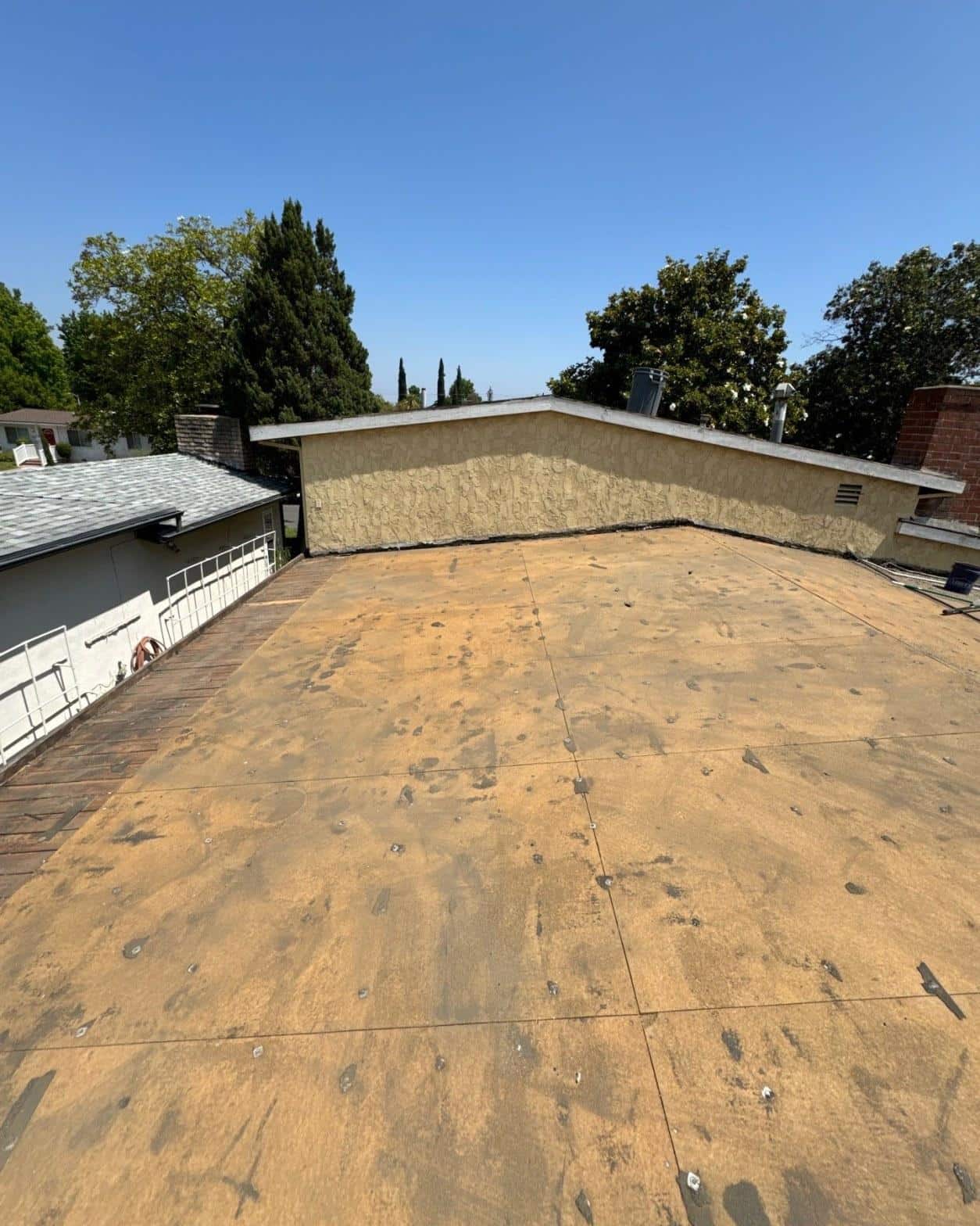 Bare plywood flat roof deck after old cap sheet tear-off on a San Fernando Valley single-family home