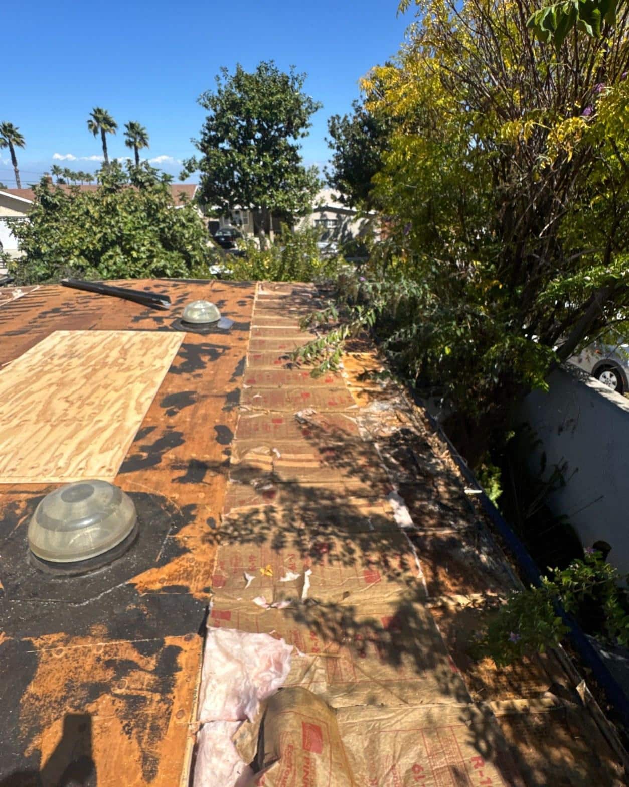 mid-century-home-standing-seam-metal-roof-skip-sheathing-4391 Torn-off roof deck exposing original 1x6 skip sheathing with water-stained boards and deteriorated rolled roofing remnants