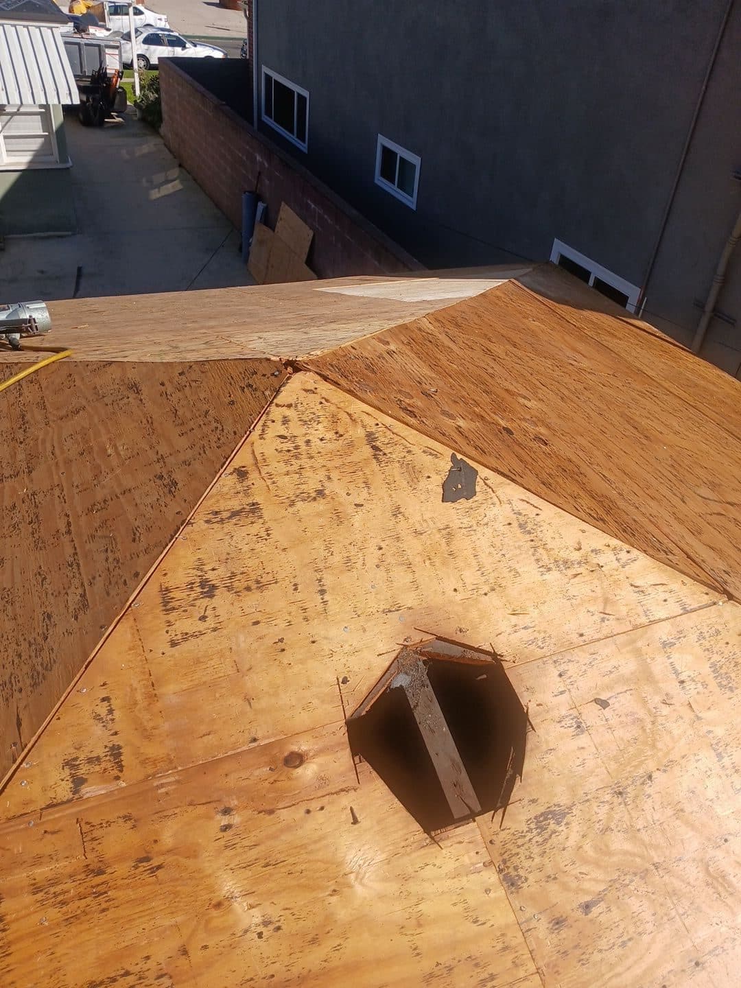 Bare plywood roof decking with open penetration cutout, hip roof — Burbank — Roof Replacement Inc