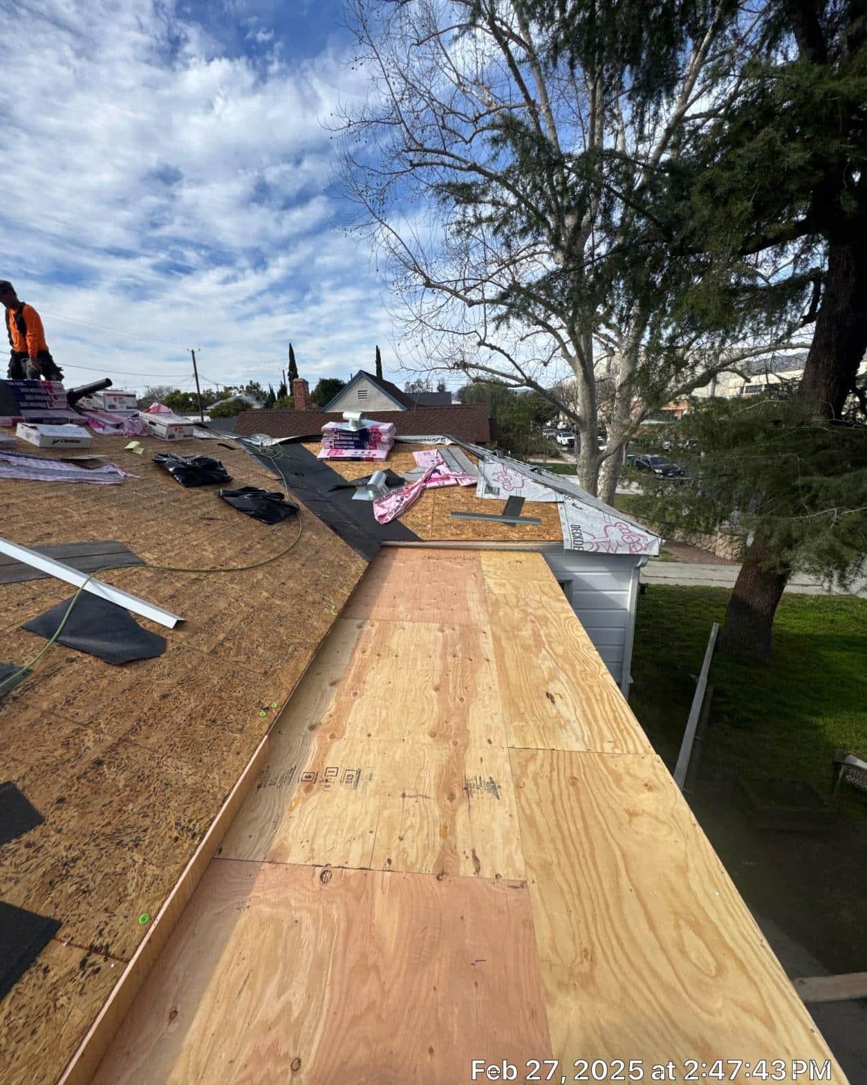 New plywood sheathing panels installed on eave section of pitched roof during tear-off reroof, Southern California