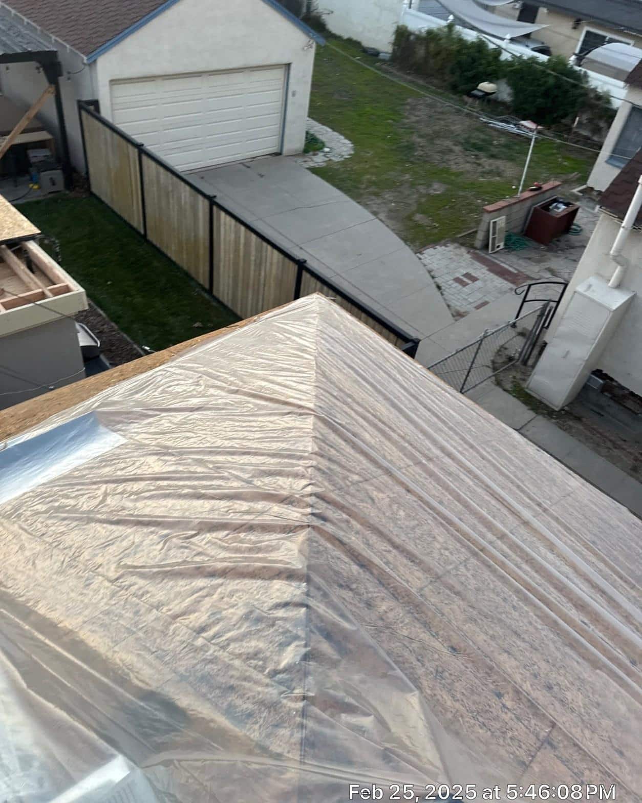 Synthetic underlayment fully wrapped over new plywood deck on hip roof before shingle installation