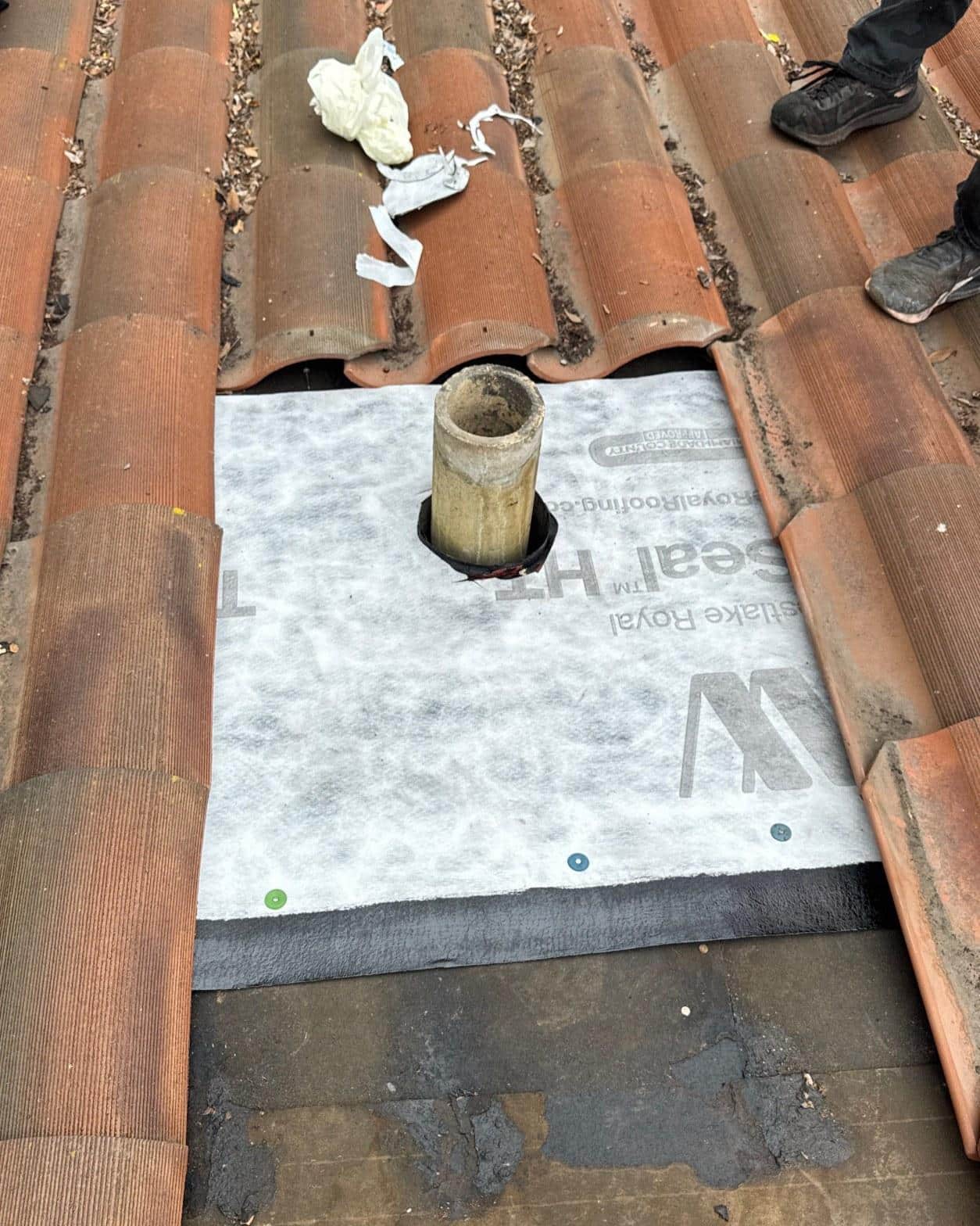 New Westlake Royal Seal HT synthetic underlayment and replacement pipe boot flashing installed on clay tile roof during repair