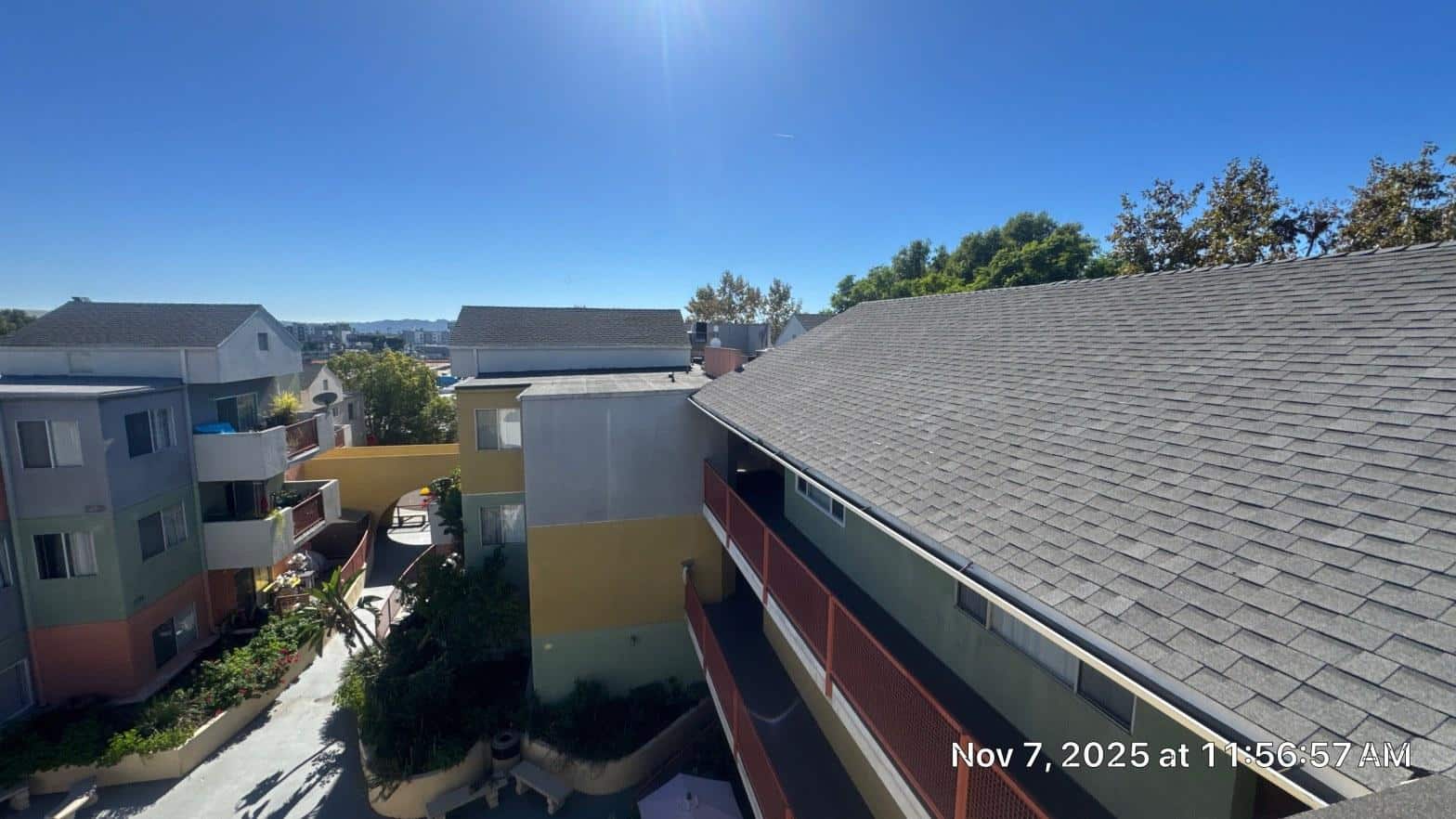 Aerial view of multi-family apartment complex showing steep-slope shingle sections and low-slope flat roof areas before torch-down reroof completion